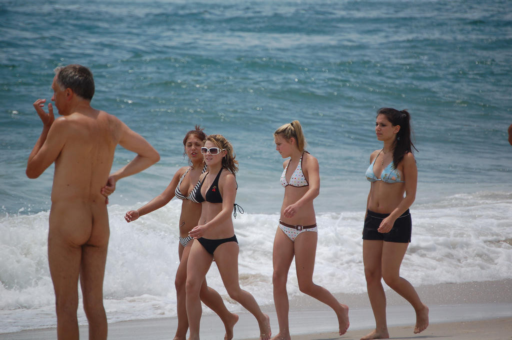 Mira a estos nudistas suaves jugar en una playa pública
 #72246941