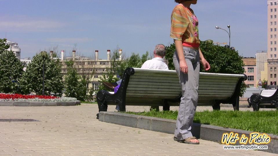 Desesperada dama se alivia en movimiento mojando sus jeans en un parque
 #73238966