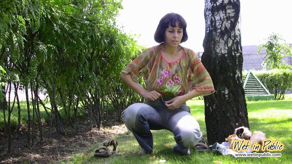 Verzweifelte Dame erleichtert sich unterwegs, indem sie ihre Jeans in einem Park einnässt
 #73239028