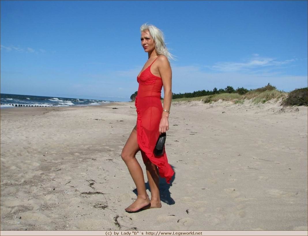 Rubia con medias marrones se desnuda en la playa
 #78024545
