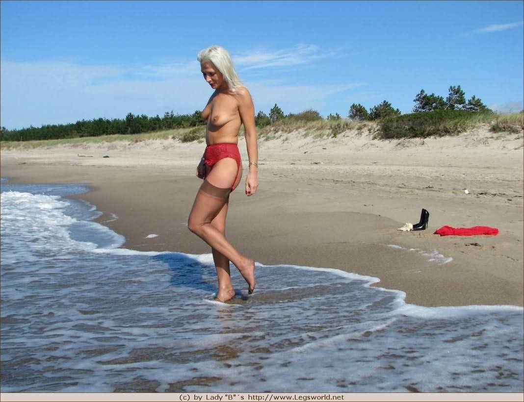 Rubia con medias marrones se desnuda en la playa
 #78024565