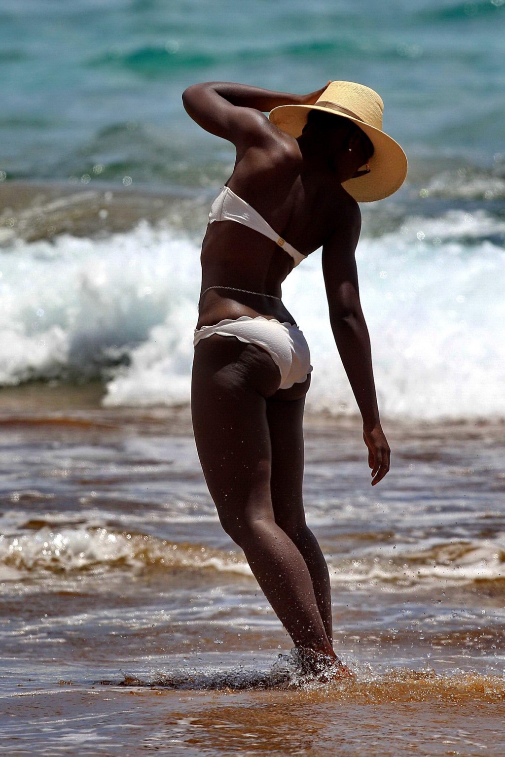 ルピタ・リョンゴがハワイのビーチで白いビキニを着て黒いお尻を見せる
 #75194773