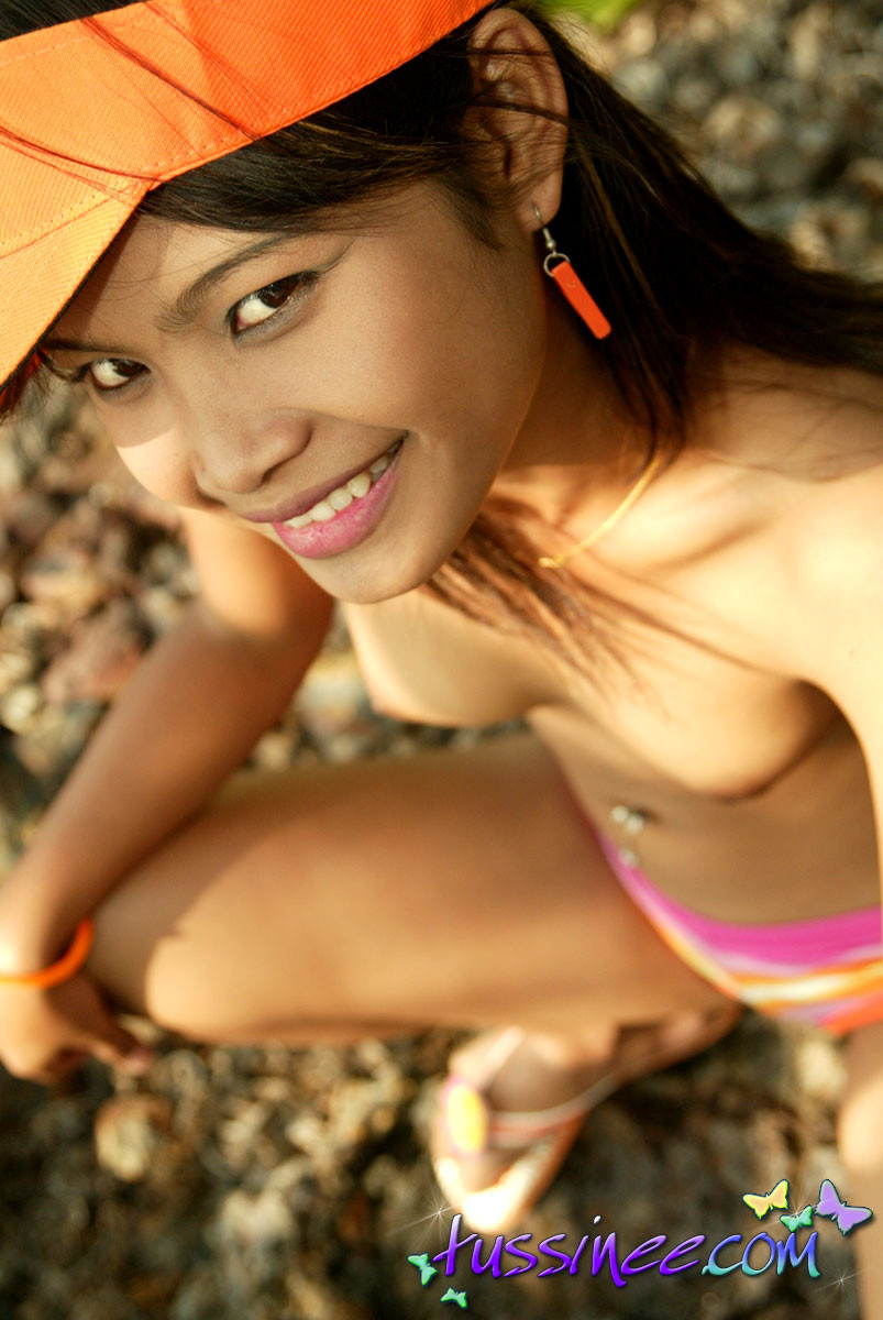 Une jolie Thaïlandaise se déshabille de son bikini et se retrouve seins nus au bord de la mer.
 #67132454