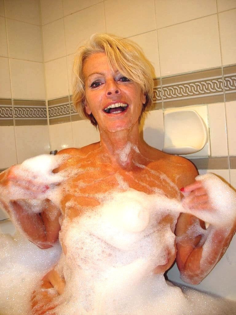 Une mamie blonde et poilue masturbant sa chatte mature et humide dans la baignoire
 #77254092