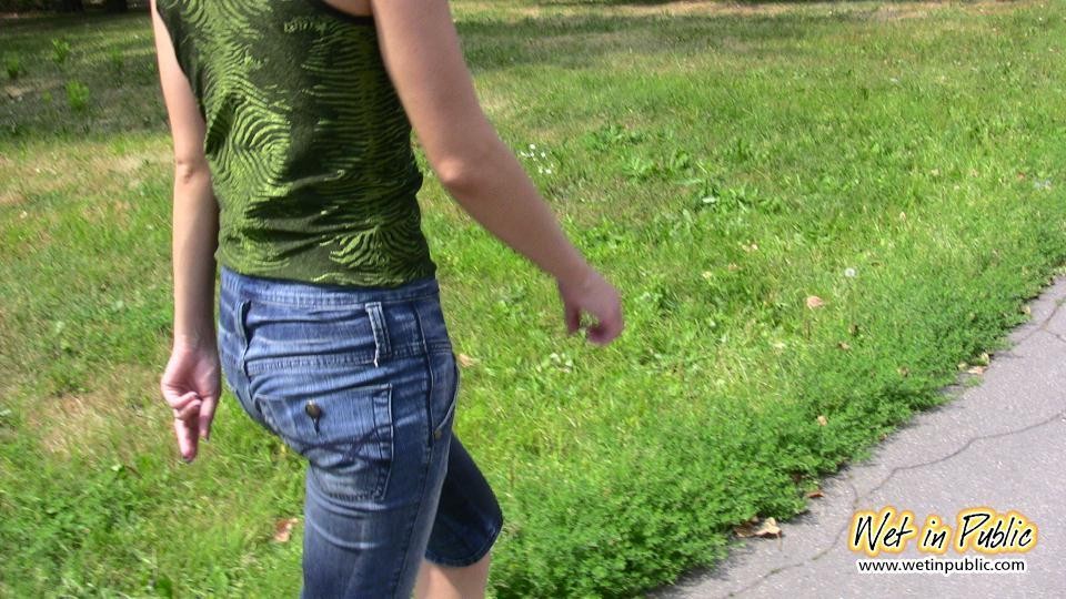 Una chica pasando por varias emociones mientras moja sus pantalones al aire libre
 #73238839