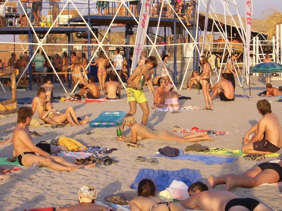 Giovani amici nudisti nudi insieme in spiaggia
 #72247807
