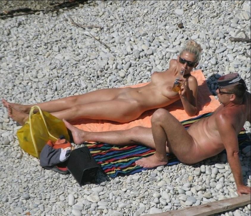 Des amies jeunes nues s'amusent sur une plage publique
 #72244164