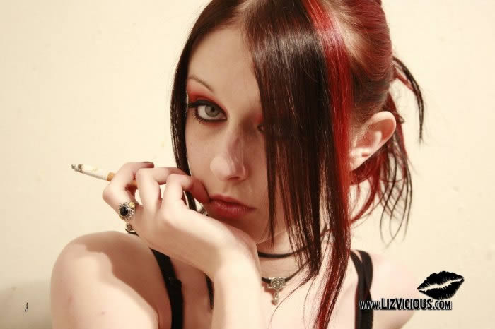 Fumante ragazza goth in posa nel suo corsetto nero
 #76591437