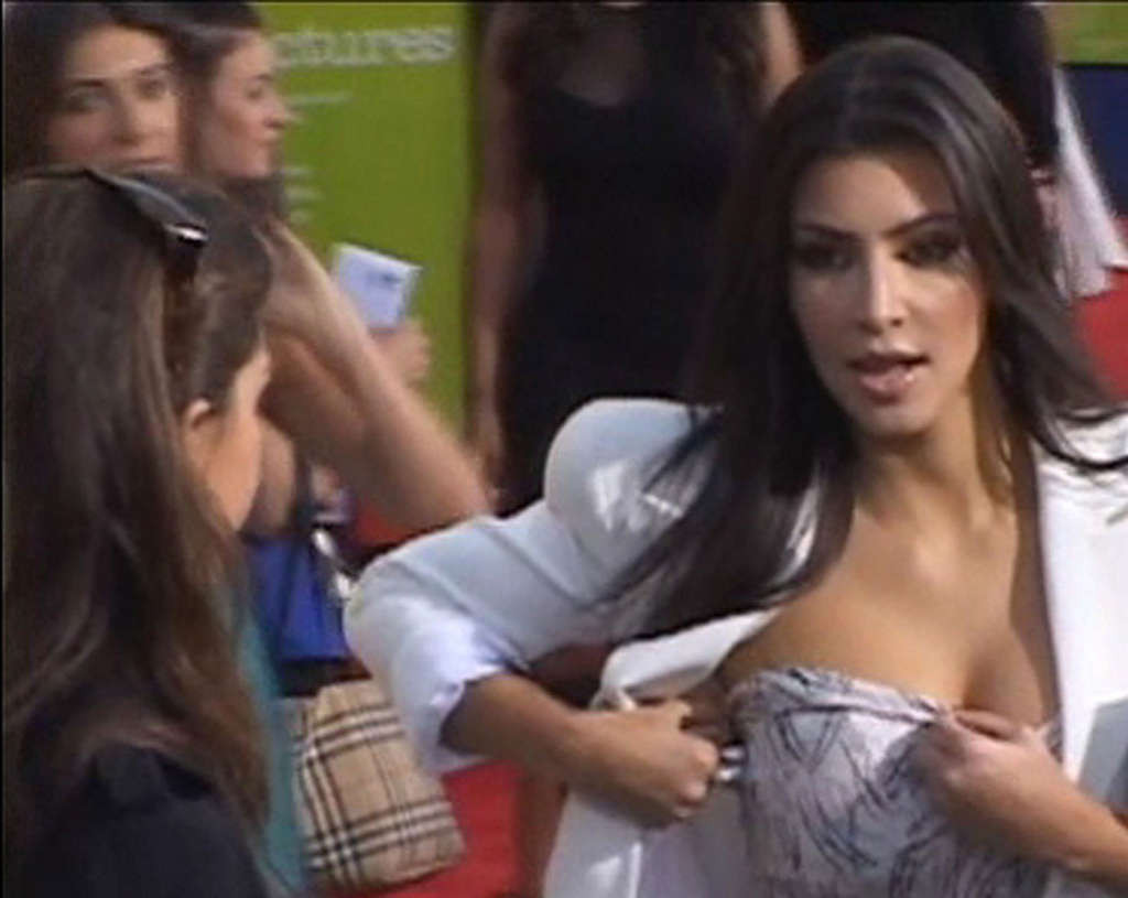 Kim Kardashian che regola il suo top di fronte alla macchina fotografica e che espone la sua bella grande t
 #75360357