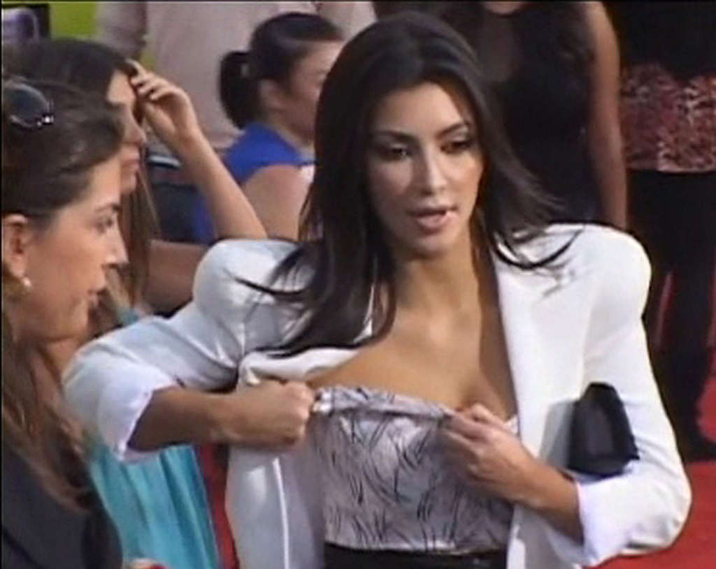 Kim Kardashian che regola il suo top di fronte alla macchina fotografica e che espone la sua bella grande t
 #75360359