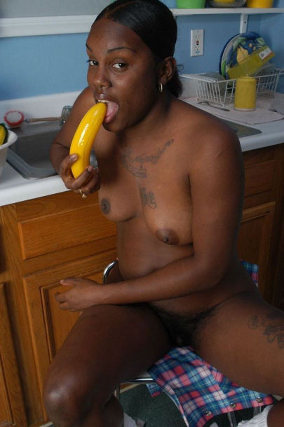 Une voisine noire nue suçant une grosse banane.
 #73442885