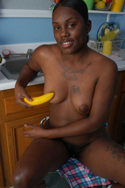Une voisine noire nue suçant une grosse banane.
 #73442893