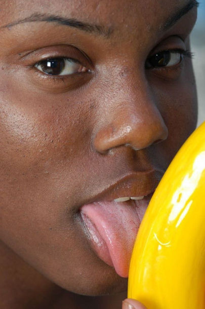 Une voisine noire nue suçant une grosse banane.
 #73442910