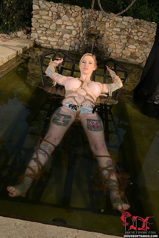 Hollie Hatton, blonde tatouée, attachée dans un cadre métallique
 #71977609
