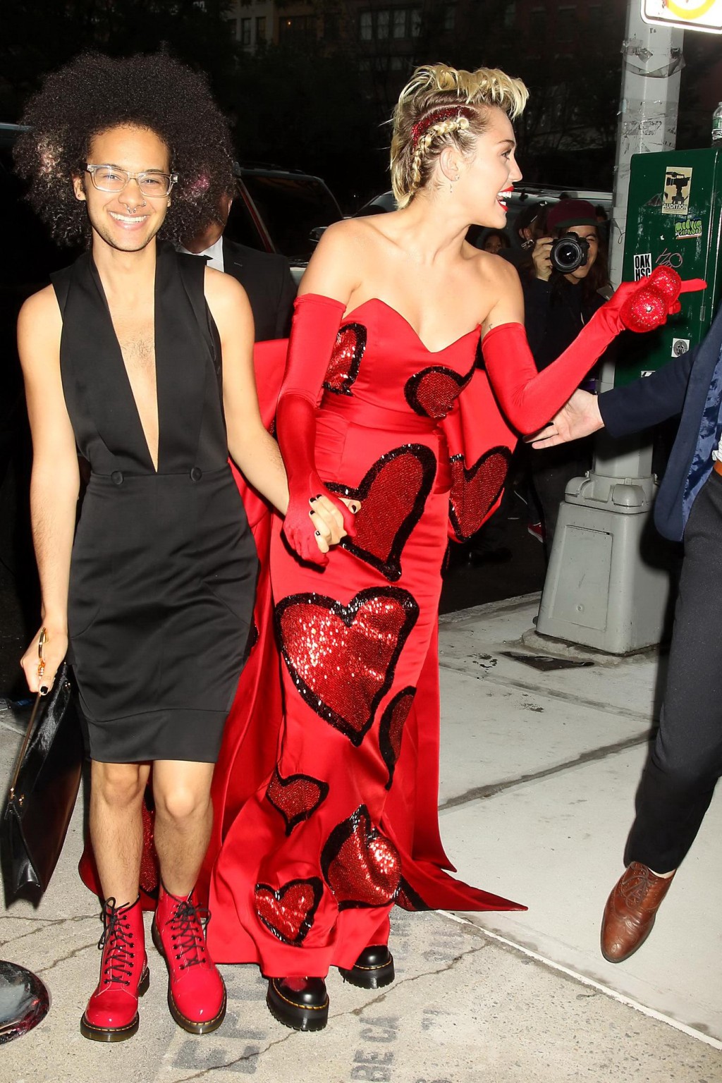 Miley Cyrus en buste dans une robe rouge sans bretelles embrassant un travesti
 #75160828