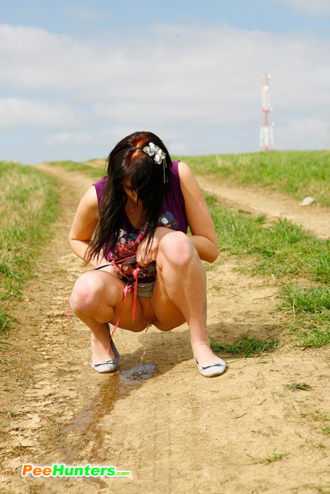 Une jeune fille coquine tache le chemin de terre avec sa pisse odorante.
 #78691180