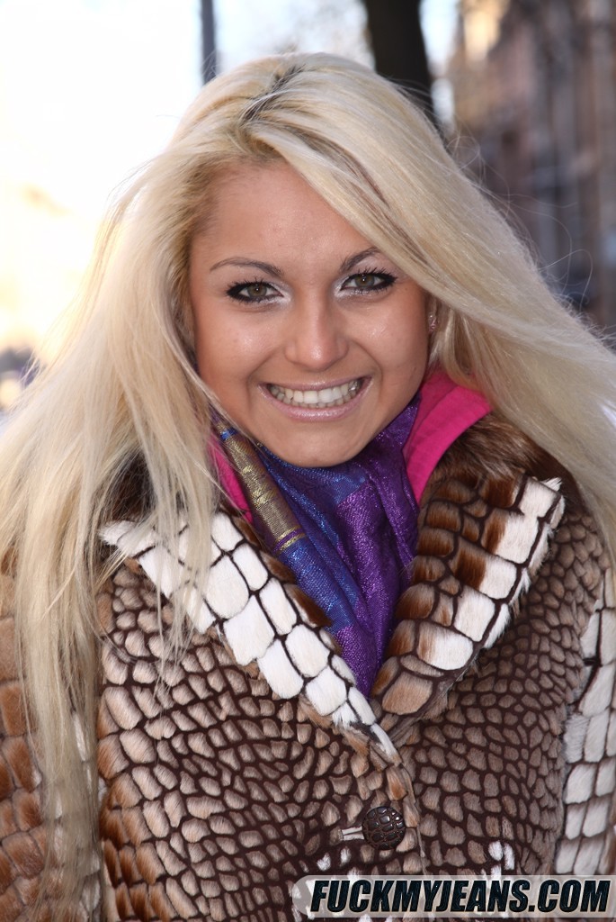 Blonde in blue jeans playing in the snow and posing on couch #71228785