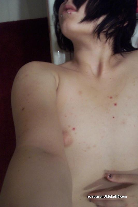 Une jeune femme perverse et percée qui montre ses seins bien fermes.
 #75701380