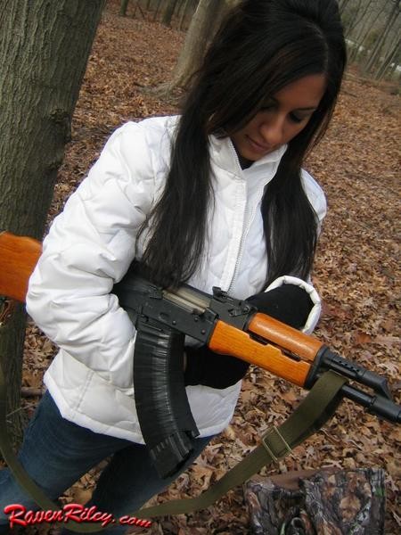 Una hermosa morena jugando con pistolas en el bosque
 #75073231