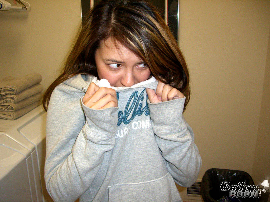 Joven despojándose de su ropa y haciendo la colada
 #78677347