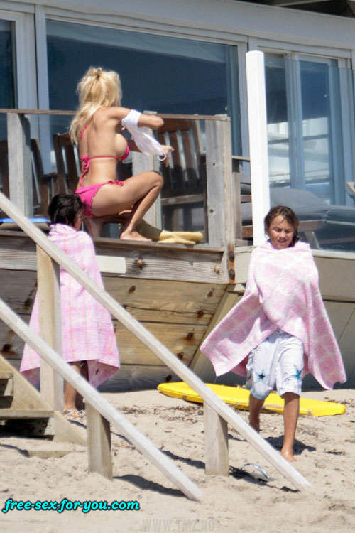 Pamela Anderson che mostra le sue grandi tette e camminare in mini gonna
 #75428395