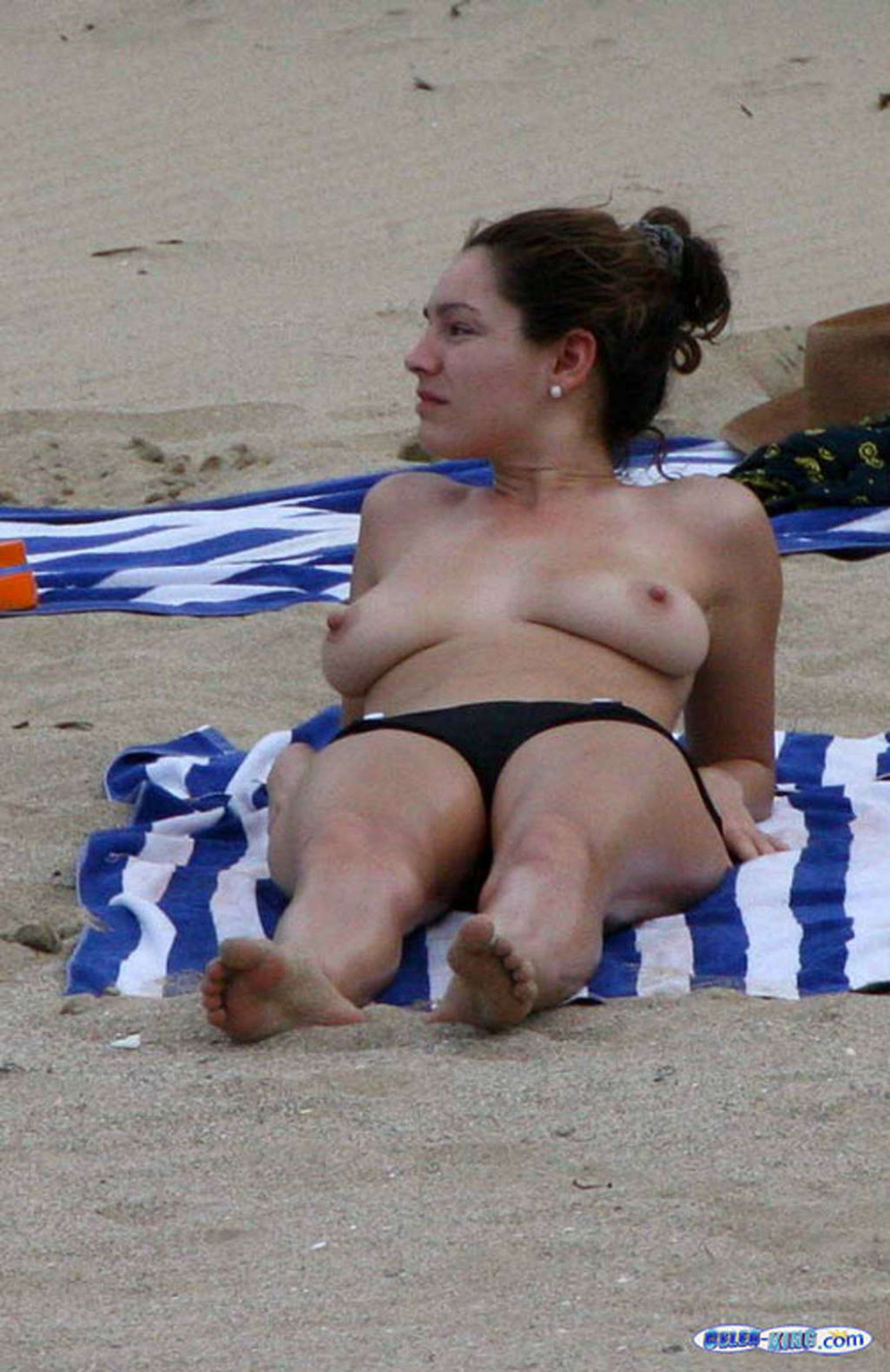 Kelly Brook montre ses jambes sexy en jupe et ses énormes seins nus sur la plage.
 #75358199