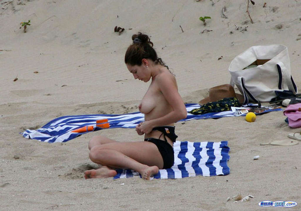 Kelly Brook montre ses jambes sexy en jupe et ses énormes seins nus sur la plage.
 #75358209