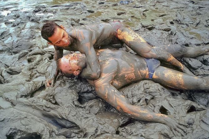 Muscle couple outdoor wrestling and thrusting the liquid mud #76947150