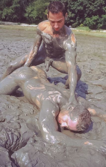 筋骨隆々のカップルが屋外でレスリングをして、液体の泥を突き刺す
 #76947158