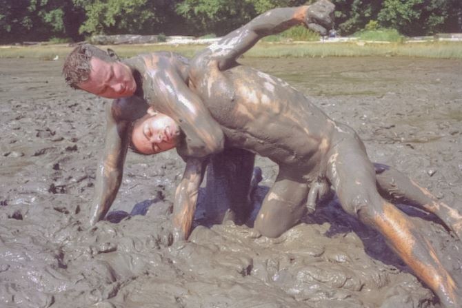 Muscle pareja al aire libre luchando y empujando el barro líquido
 #76947163