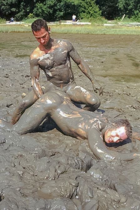 Muscle couple outdoor wrestling and thrusting the liquid mud #76947174