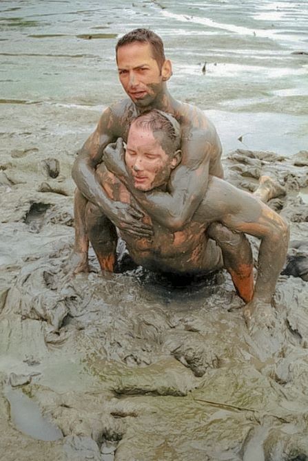 Muscle couple outdoor wrestling and thrusting the liquid mud #76947182