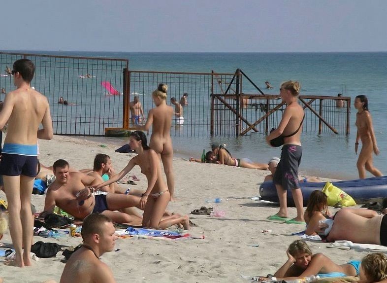 Joven nudista con pechos grandes se desnuda en la playa
 #72257182