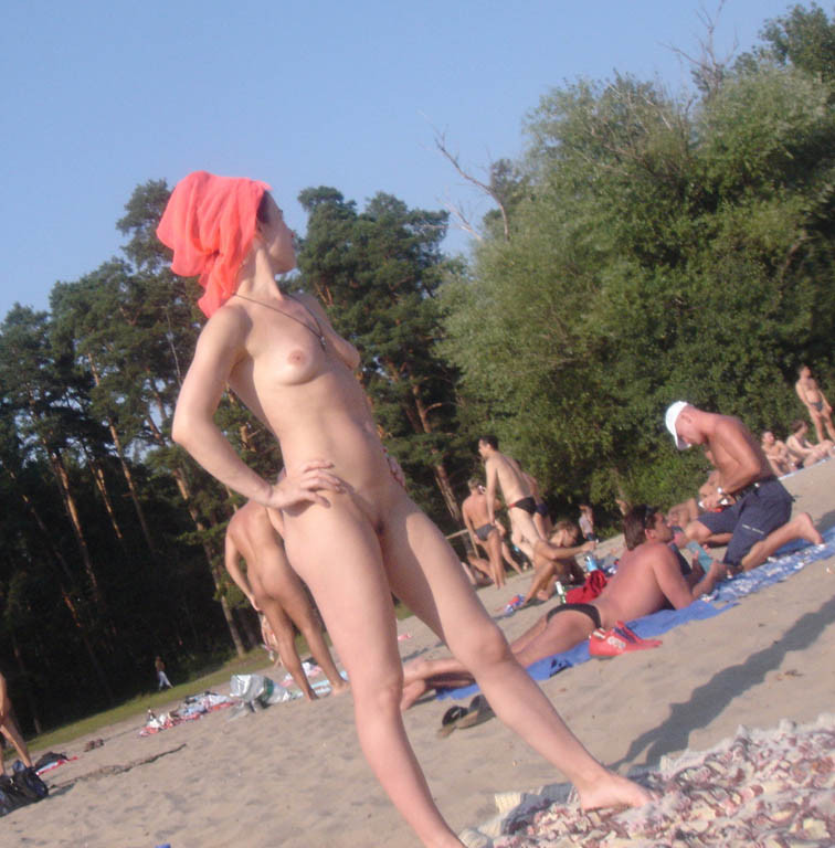 Une jeune nudiste à peine majeure s'allonge nue sur la plage.
 #72248981
