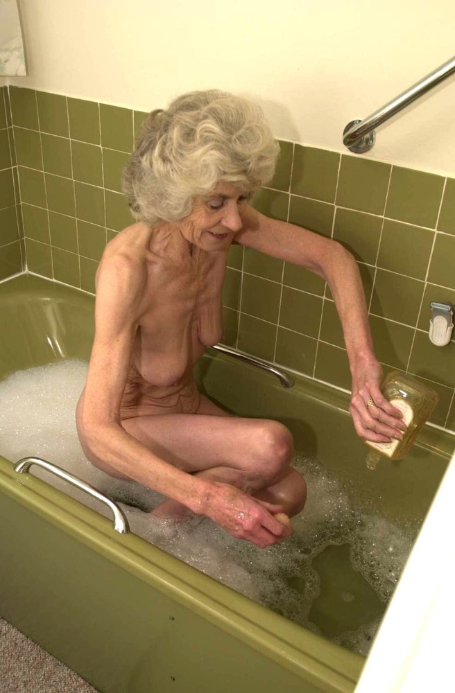 Vieille mamie extrêmement vieille jouant avec sa chatte ridée dans la baignoire
 #71652074