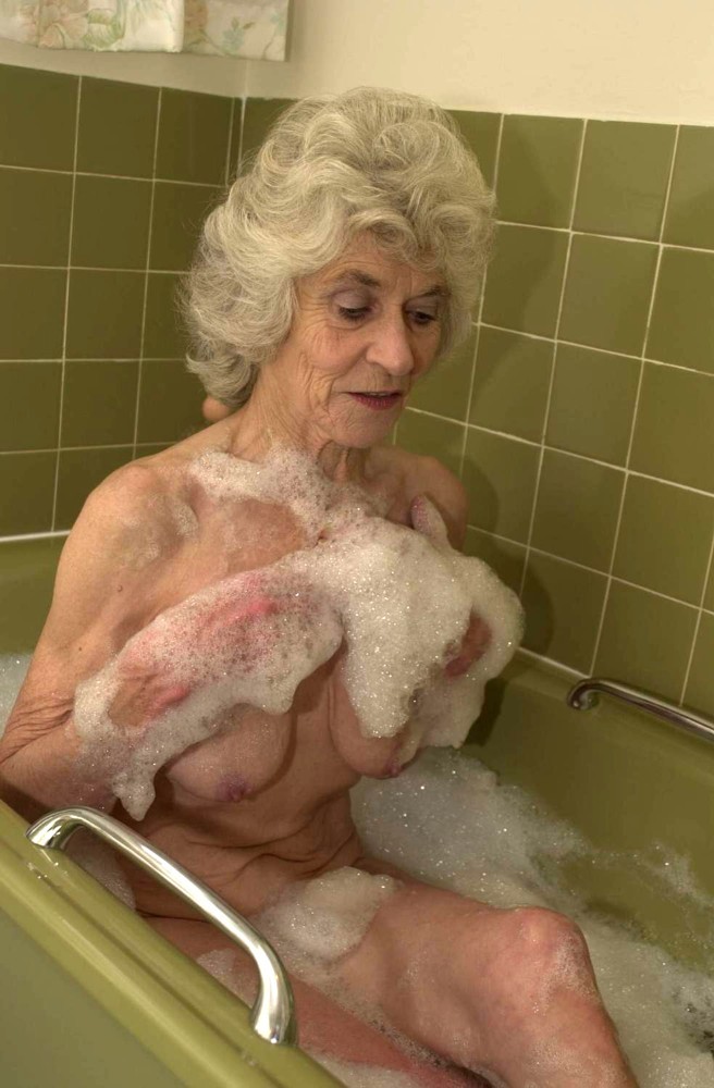 Vieille mamie extrêmement vieille jouant avec sa chatte ridée dans la baignoire
 #71652086
