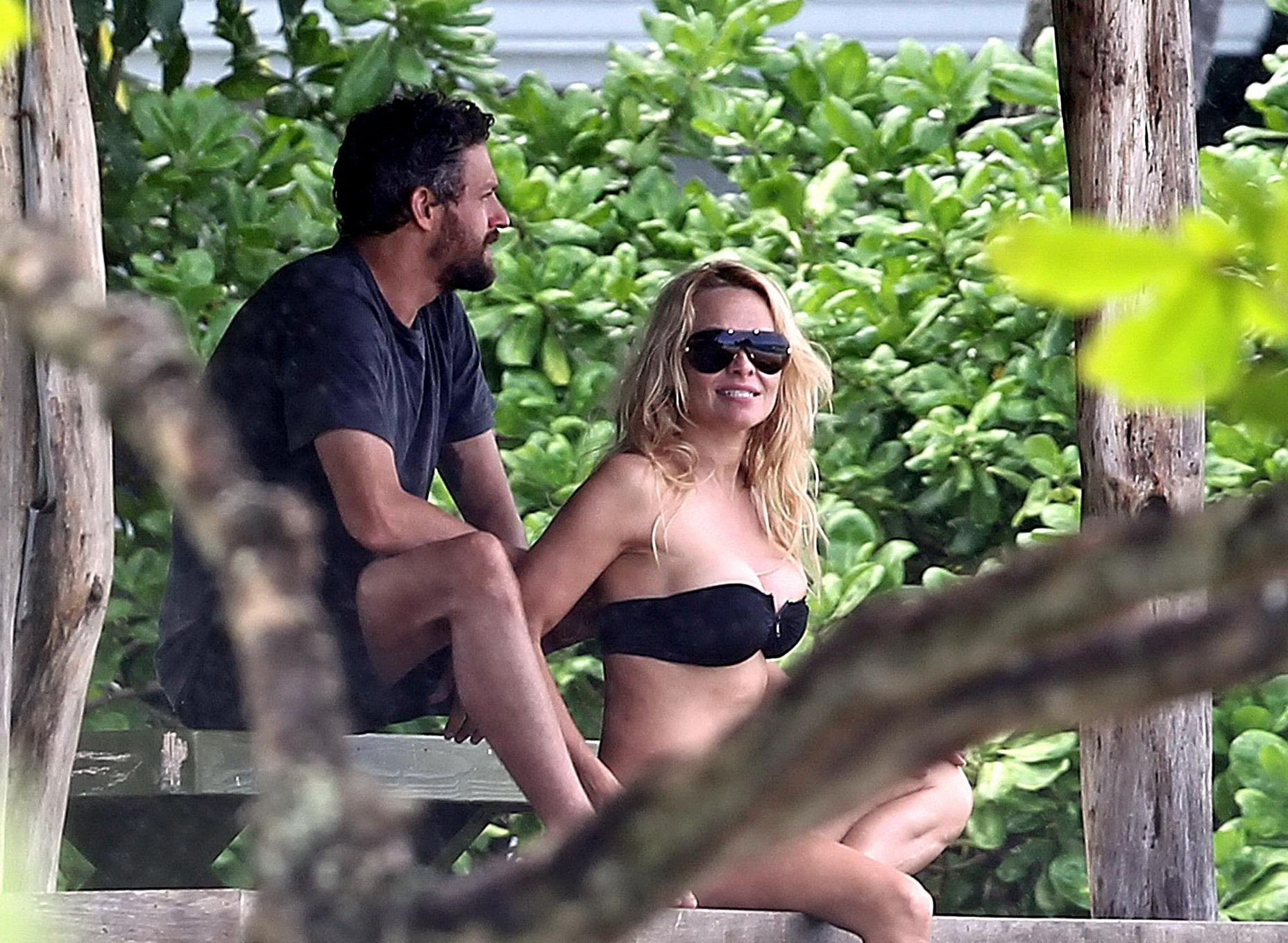Pamela Anderson vollbusig im trägerlosen schwarzen Bikini am hawaiianischen Strand
 #75278578