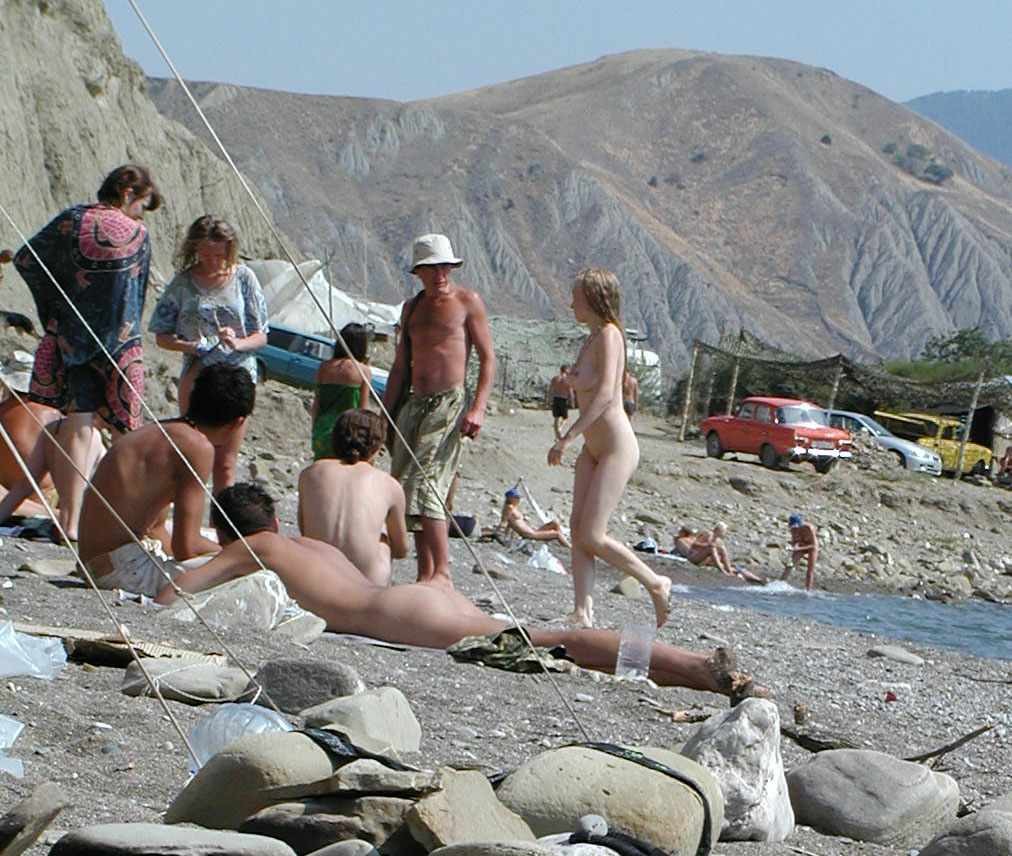 Nudista giovane dai capelli corvini si stende sotto il sole caldo
 #72253104