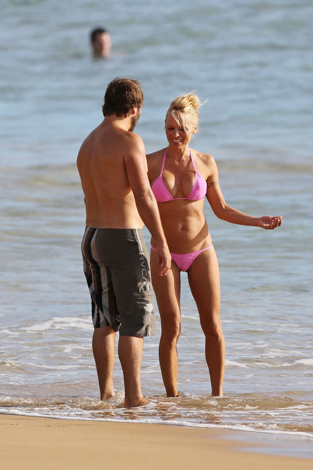 Pamela anderson montre ses seins en portant un bikini transparent mouillé sur une plage. 
 #75222210