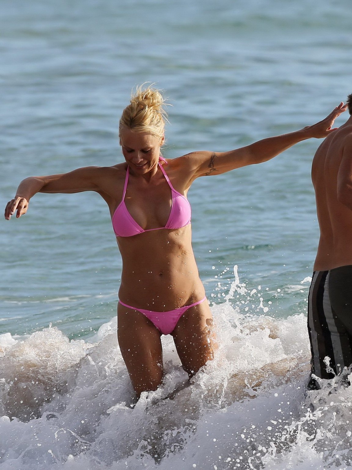 Pamela anderson montre ses seins en portant un bikini transparent mouillé sur une plage. 
 #75222238