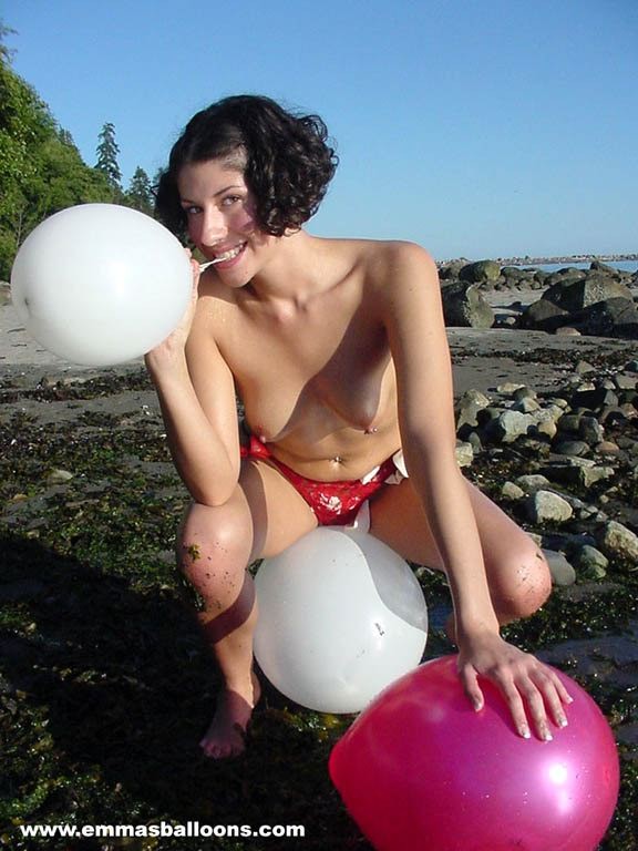 Une brune amateur jouant avec des ballons sur la plage
 #72317177
