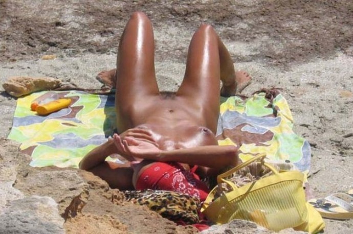 Una ragazza nudista a malapena legale si illumina in spiaggia
 #72249554