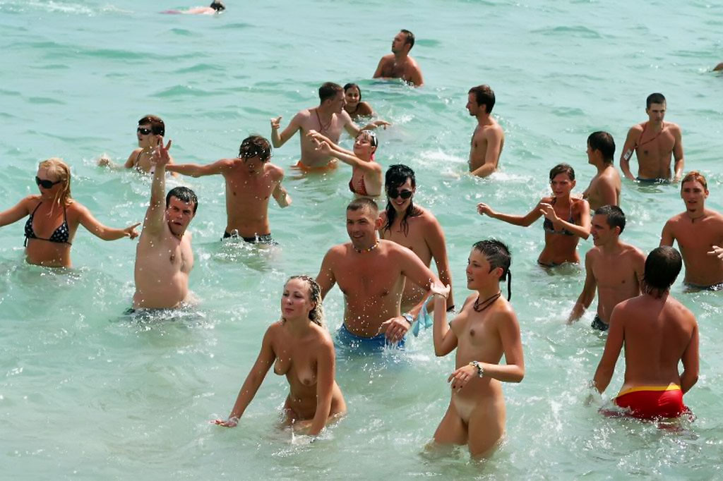 Jeunes sexy et nus jouant sur une plage publique
 #70305902