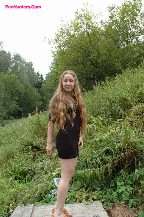 Una joven sucia se sienta a mear en una mesa de picnic
 #78691585