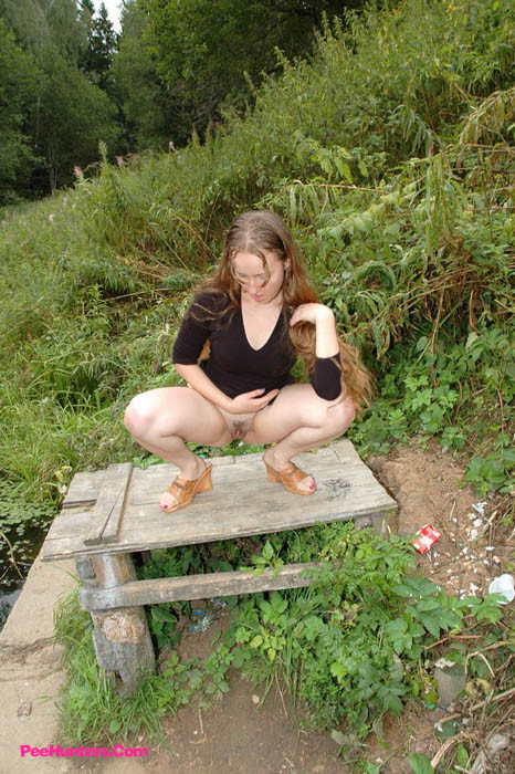 Dirty teen slut sitzt zum Pissen auf einem Picknick-Tisch
 #78691616