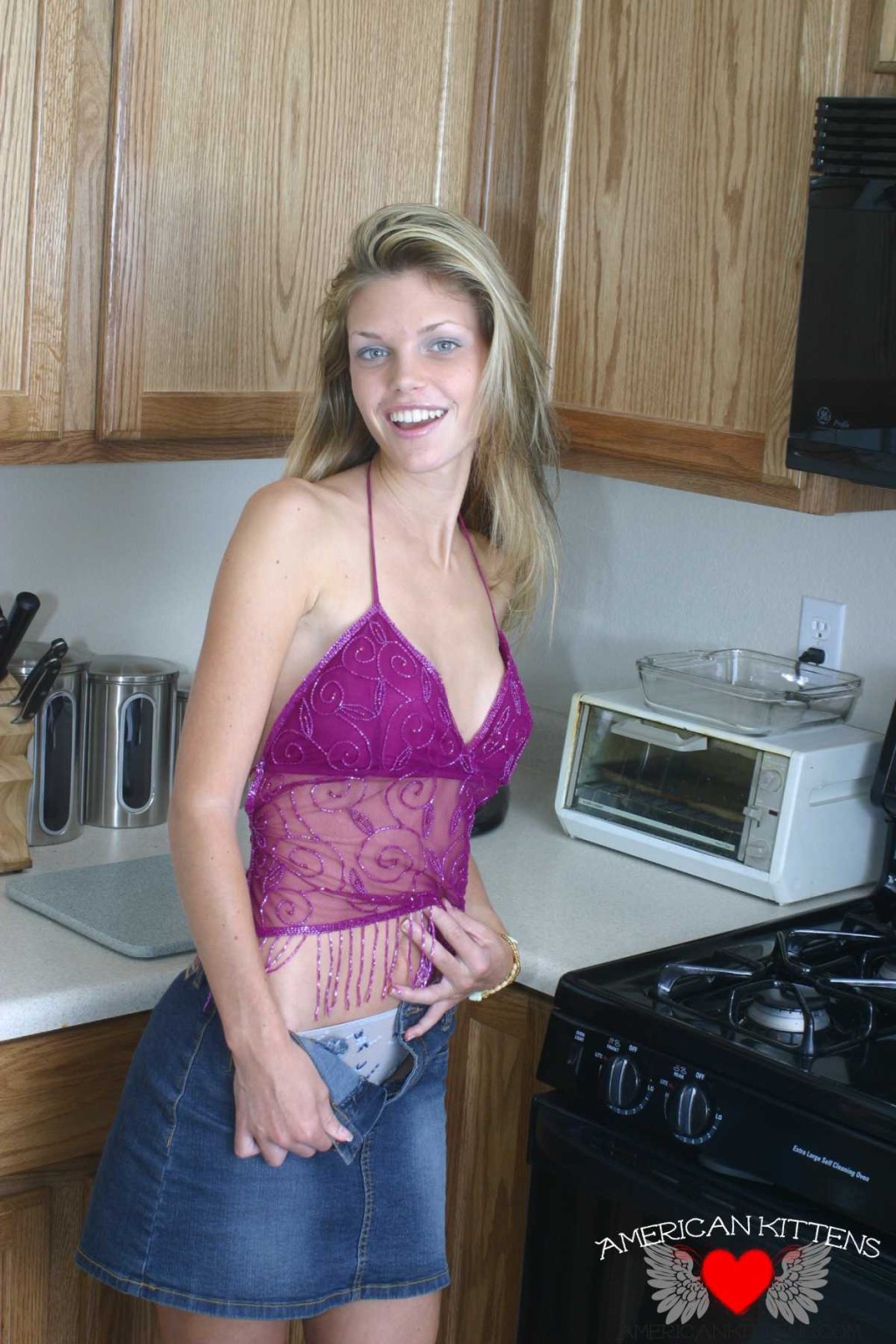 アシュリーは、薄手のトップスとジーンズのスカートを着て、再びキッチンで食事を楽しんでいる。
 #77152039