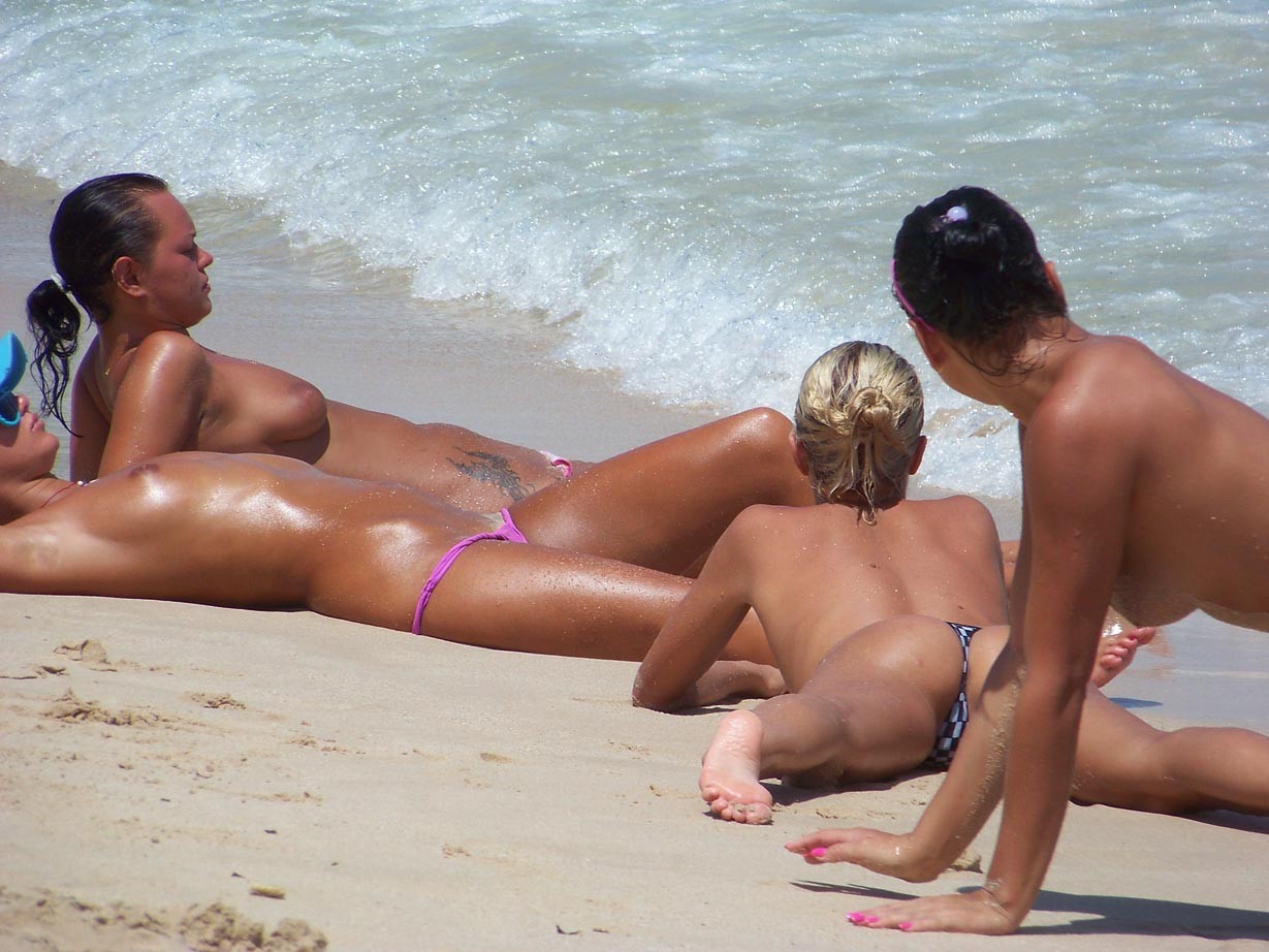 Des amis nus s'amusent sur une plage publique
 #72244792