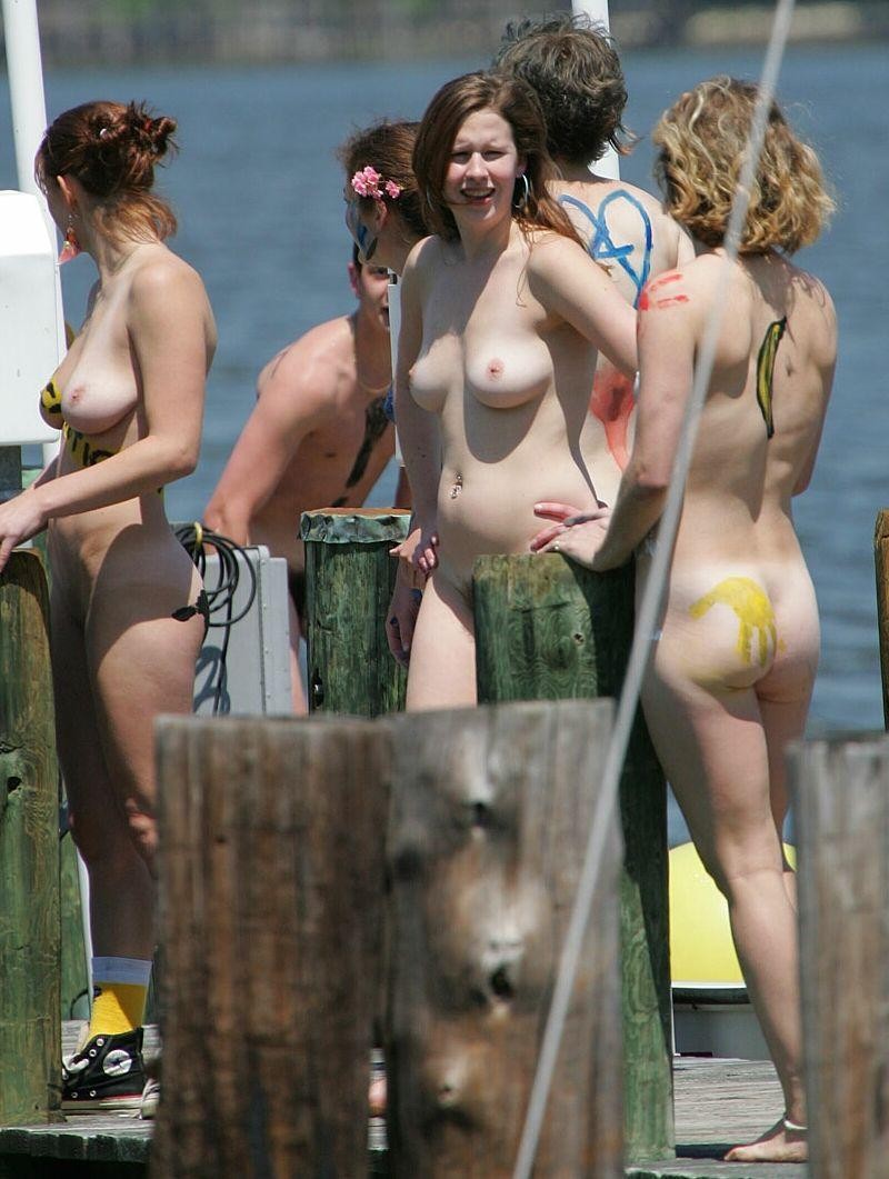 Amigos desnudos juegan en una playa pública
 #72244822