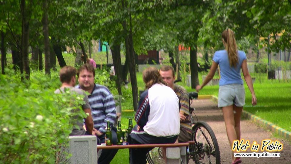 Une fille avec une longue queue de cheval qui s'étale et se mouille sur un banc de jardin.
 #73238549