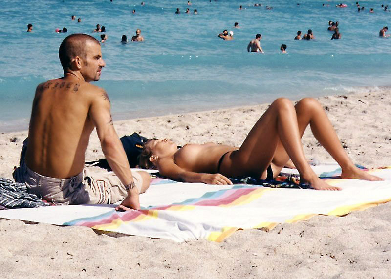 Une jeune femme sexy aux seins volumineux pose sur une plage nue.
 #72251833